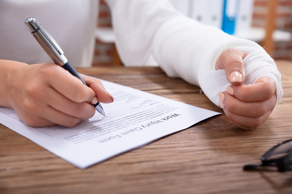 Injured woman filling out a workers compensation claim