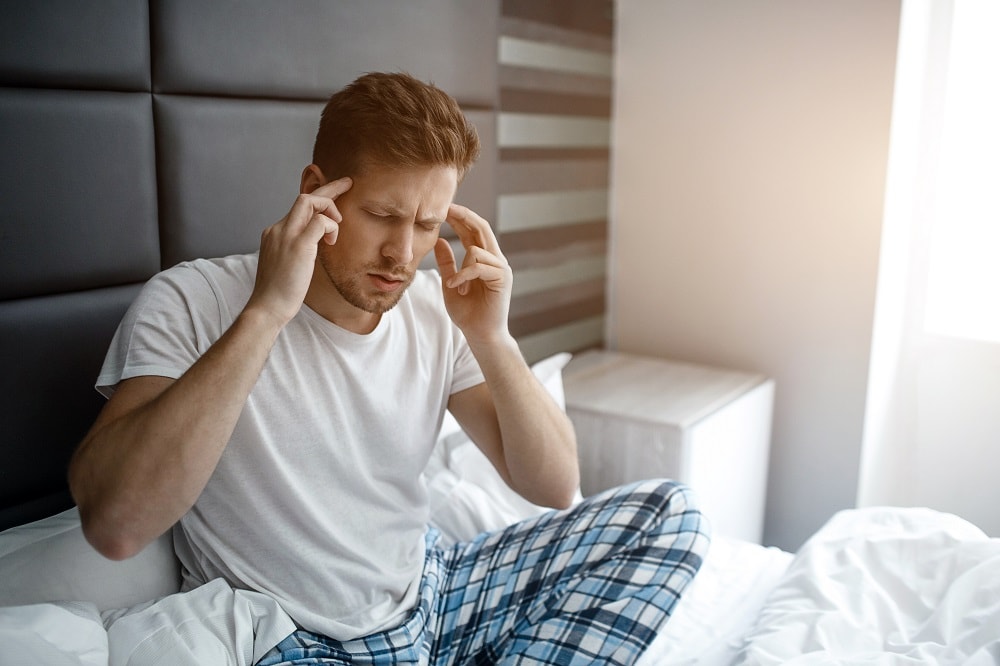 Young man feeling dizzy after waking up.