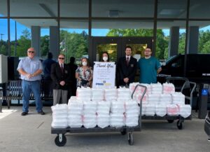 Sherrod and Bernard crew standing behind carts of donated meals