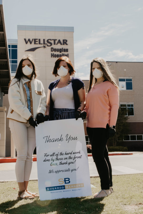 Staff from Highlanders Tavern and Pub holding thank you banner