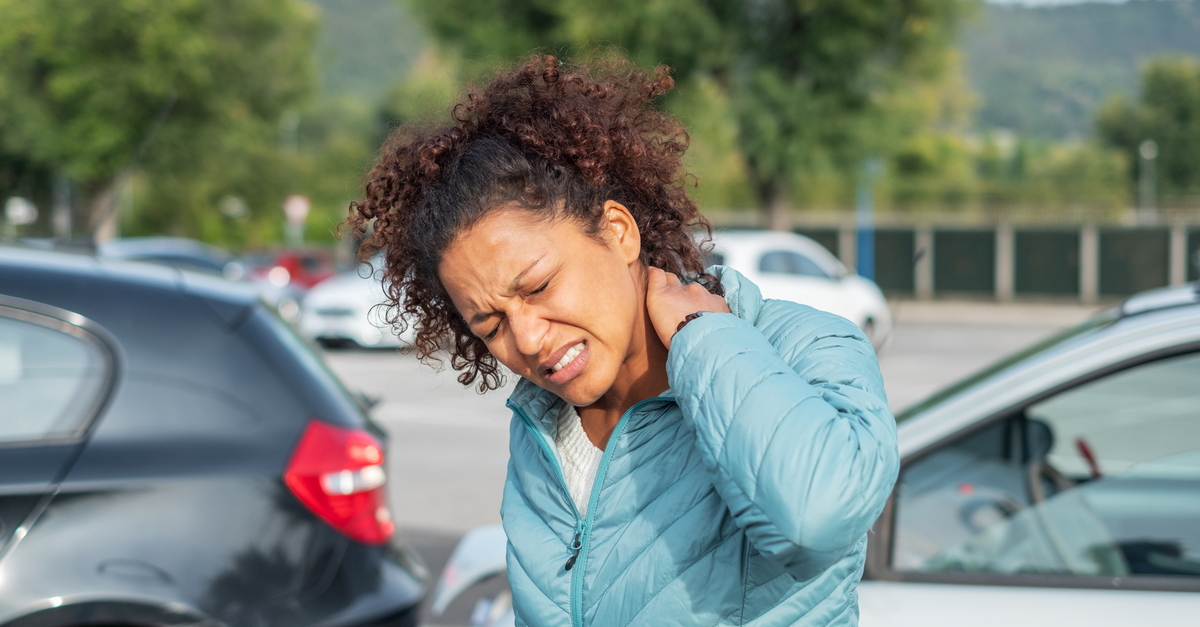 Injured woman experiencing whiplash after car accident.