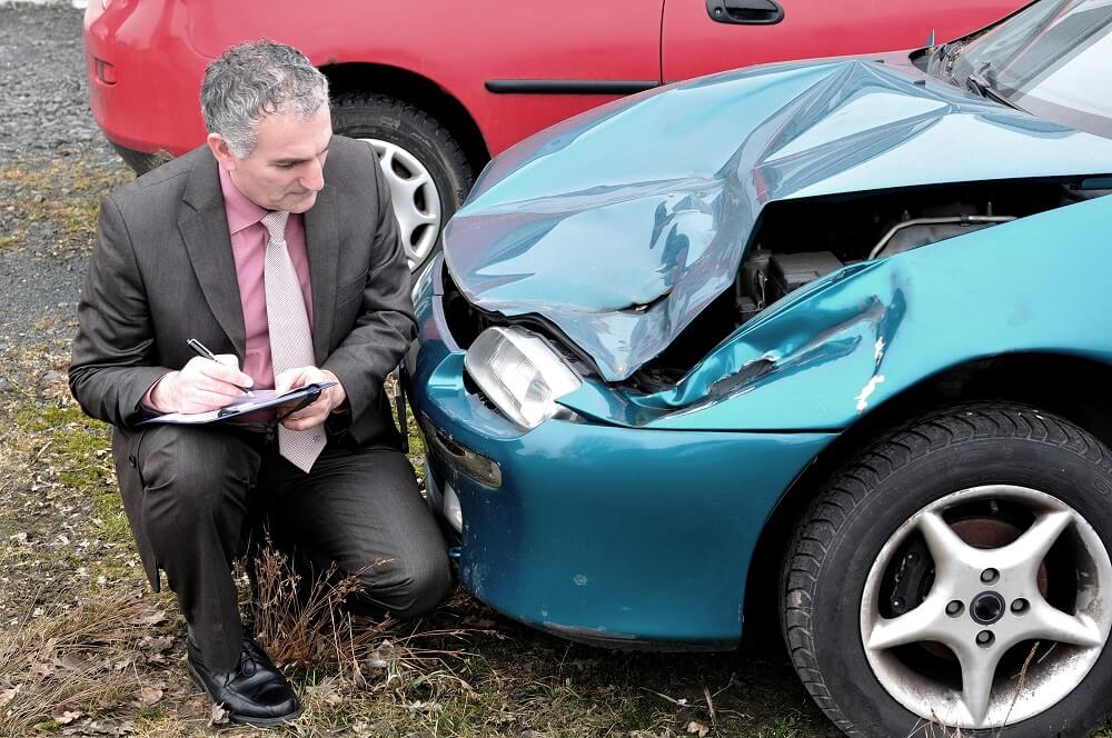 Insurance agent checking for the car damages.