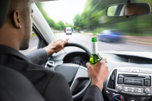 Driver drinking liquor while driving.