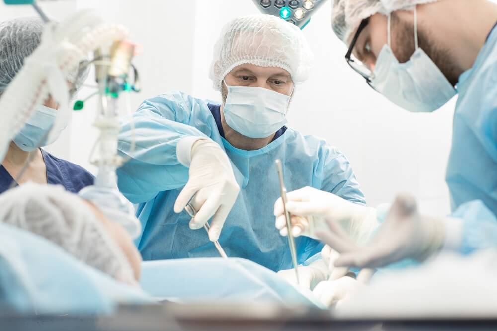 Team of surgeons operating critical patient.