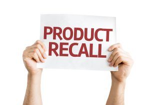 hands holding up a sign saying product recall