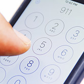 person dialing 911 on cell phone
