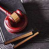 A red gavel sitting on top of two books.