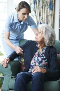 senior in nursing home being helped by nurse