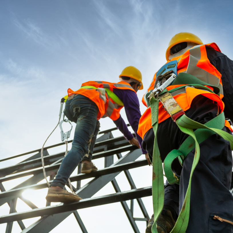 construction workers with safety straps on a roof 
