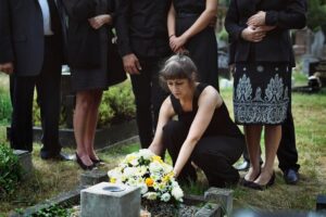 Family laying flowers on the grave.