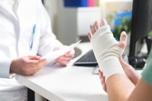 Patient with injured hand consulting physician.