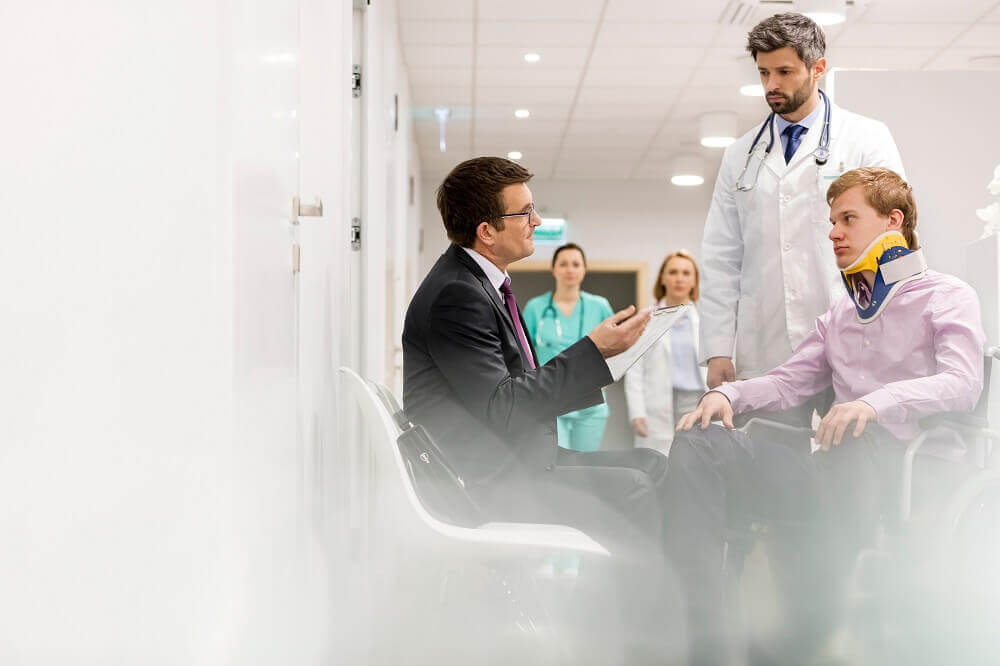 Lawyer and doctor talking to the injured patient.