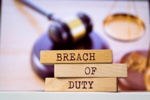 Wooden blocks with words 'BREACH of DUTY' legal concept.