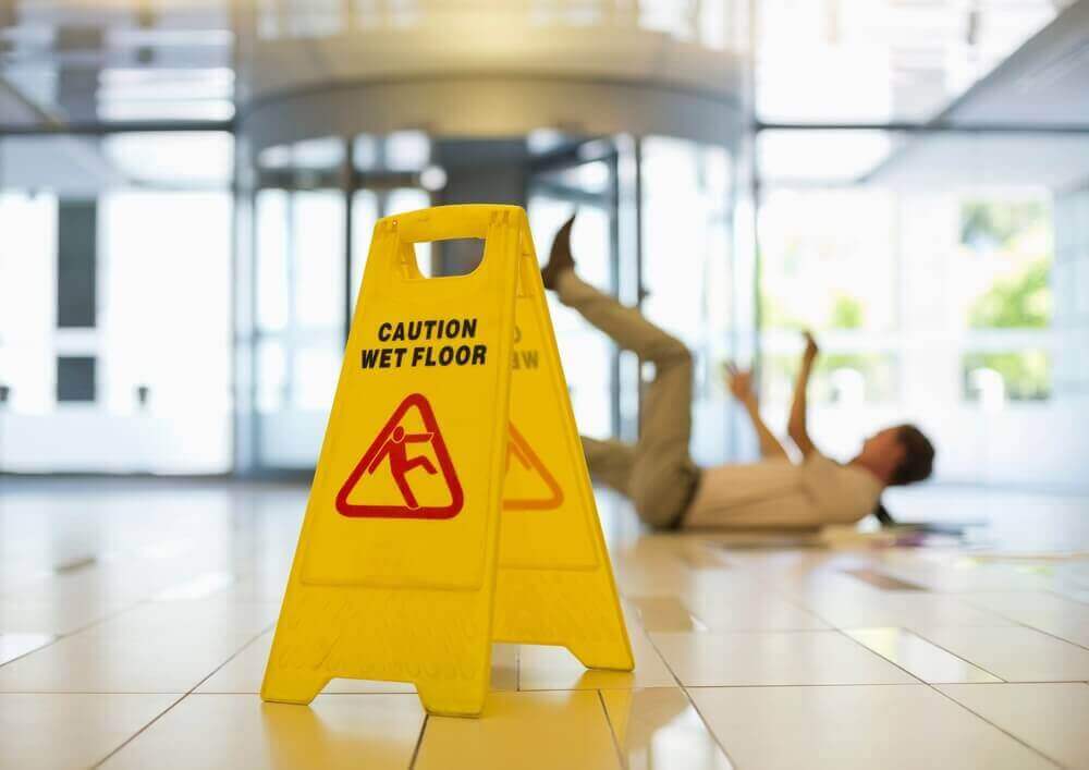 Office worker slipping from wet floor inside the premises.
